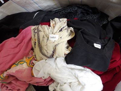 une pile de vêtements posée sur un lit