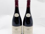 deux bouteilles de vin rouge posées l'une à côté de l'autre sur une surface blanche