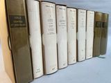 several books are lined up in a row on a white surface
