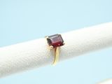 an image of a ring with a red stone on it