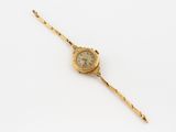 an image of a gold wrist watch on a white surface
