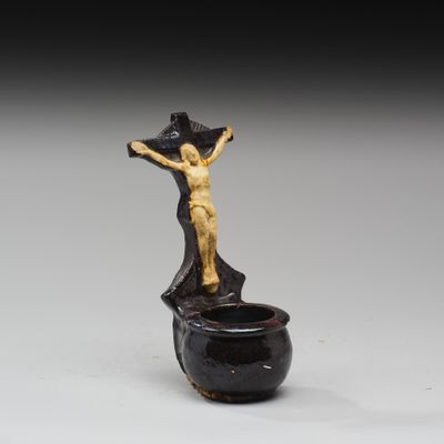une image représentant une statue d'une personne sur une croix posée sur un pot