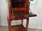 un petit bureau en bois avec un miroir accroché au mur