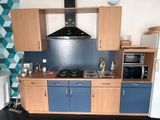 une cuisine avec des placards bleus et une plaque de cuisson noire