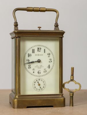 une petite horloge et une clé posées sur une table