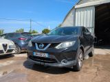 La voiture est garée devant un garage, avec d'autres voitures en arrière-plan.