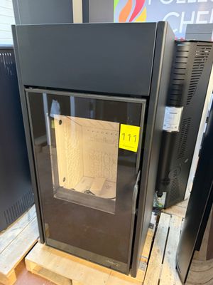 a black stove sitting on a pallet in a room