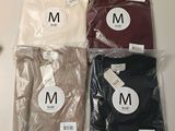 three pairs of men ' s t - shirts in plastic bags on a table