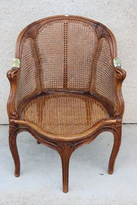 une vieille chaise avec une structure en bois et une assise en osier