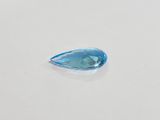 a close up of a tear shaped blue topaze stone on a white surface