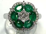 an image of a green and white diamond ring on a clear stand