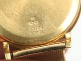 a close up of a person holding a gold wrist watch