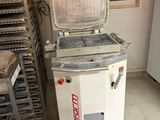 a machine that is sitting in a kitchen next to a stack of pans