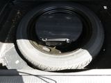 un pneu dans le coffre d'un camion dont un pneu est à plat