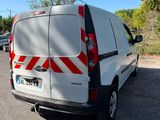 une camionnette blanche avec des bandes rouges et blanches garée dans un parking