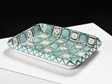 green and white patterned tray on a white table with a black background