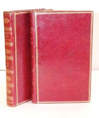 two red books sitting next to each other on a white surface