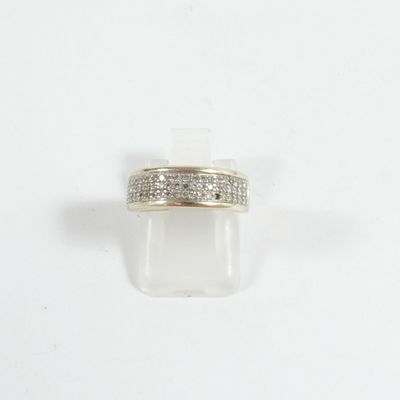 gros plan d'une bague avec des diamants sur une surface blanche
