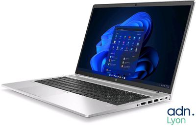 l'ordinateur portable est ouvert sur une surface blanche avec un fond bleu