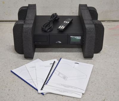 une télécommande et un cahier posés par terre