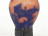 a blue and orange vase sitting on a stand