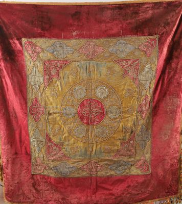 an old red and gold tapestry hanging on a wall