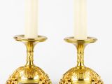 pair of brass candlesticks with turtle heads on each of them