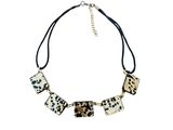 un collier à motif léopard noir et blanc monté sur un cordon noir