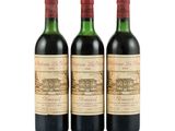 three bottles of red wine sitting next to each other on a white surface