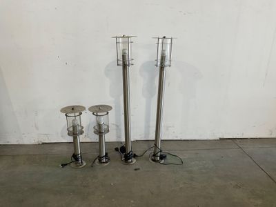 trois bougies en métal posées par terre