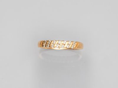 une bague en or jaune sertie de cinq diamants sur fond blanc