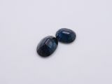 a pair of blue sapphires on a white surface