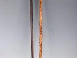 two wooden canes sitting next to each other on a white surface