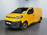 La camionnette jaune est garée dans une grande pièce blanche.