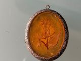 a picture of a small pendant with a leaf on it