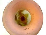 a pink glass vase with a green and white design on it