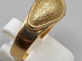 a close up of a gold ring on a white surface