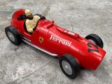 une petite voiture rouge avec un ours en peluche à l'intérieur