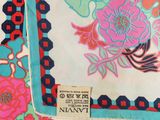 a close up of a floral print bag with a tag on it