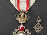 an image of a medal with a red cross on it