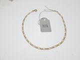 a close up of a gold chain bracelet with a price tag on it