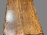 an old wooden table with a drawer underneath it on a gray surface