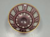 a purple bowl with a gold rim on a white table