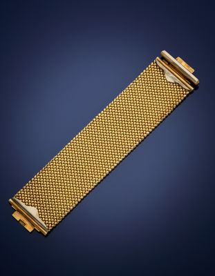 a gold bracelet with a clasp on a blue background