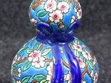 un vase bleu avec des fleurs posé sur une table