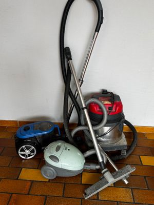 un aspirateur et une petite voiture posée par terre