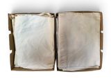 an open box with two sheets of paper in it on a white surface