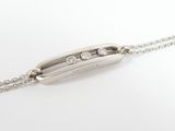 a close up of a silver necklace with diamonds on a chain