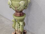 a green planter sitting on top of a wooden stand