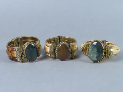 trois bagues ornées de pierres différentes, posées sur une table